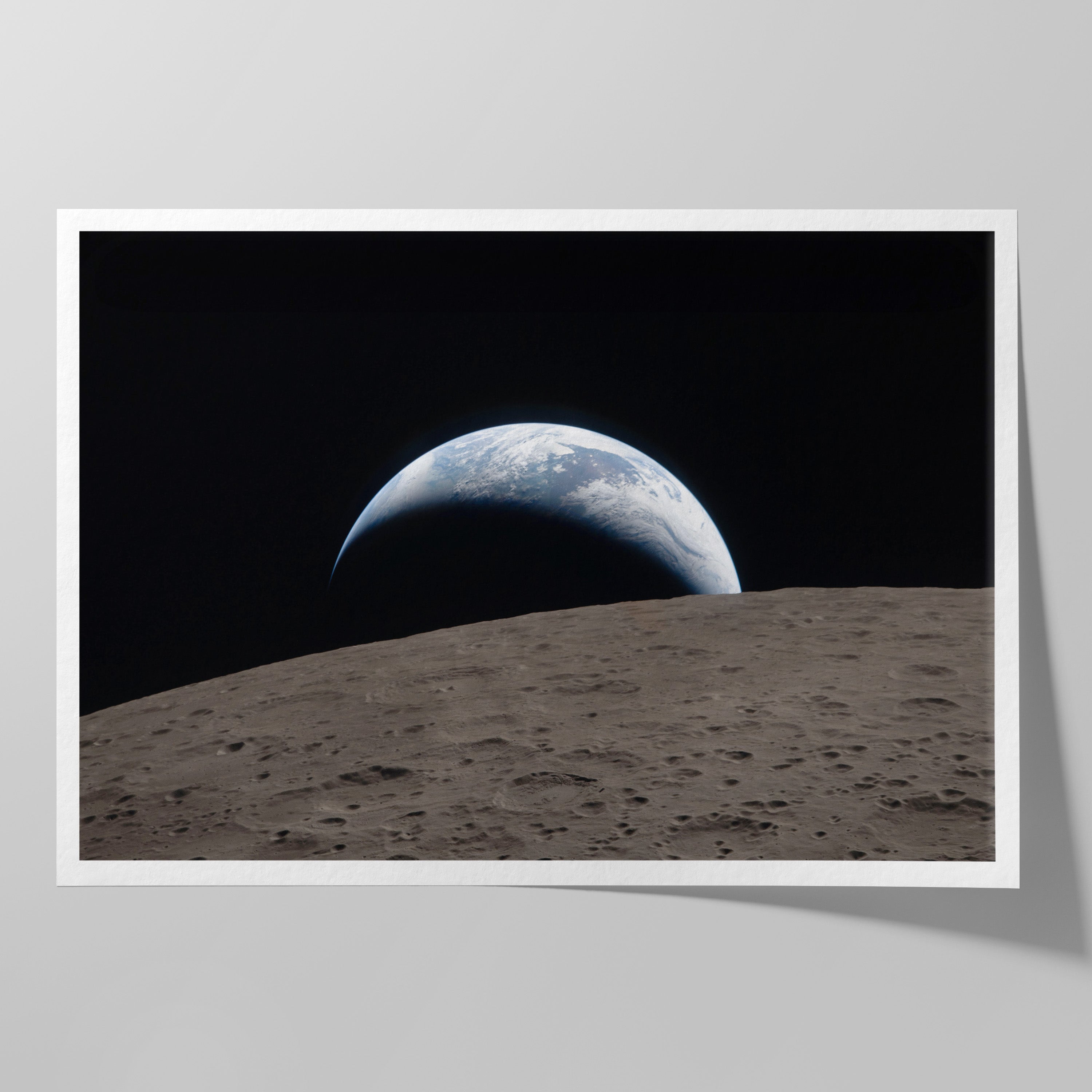 A crescent Earth setting behind the cratered lunar horizon, photographed by the Artemis II crew during the Moon flyby.
